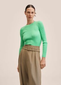 Lime green ribbed knit sweater on woman with brown hair wearing it with a brown set of trousers
