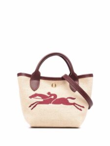 Cream handbag with fuschia horse on it and has maroon handles.