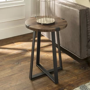 Small round wooden side table with black metal legs.