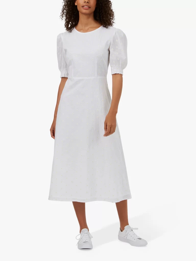 White midi dress styled with trainers for graduation outfit.