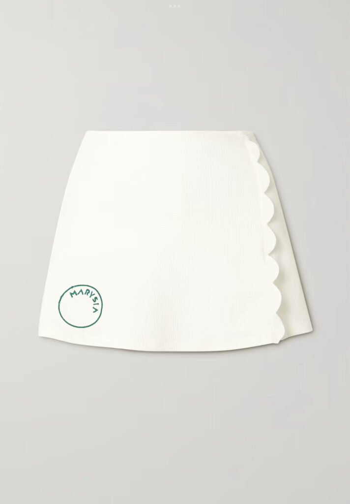 White tennis skirt with green logo.