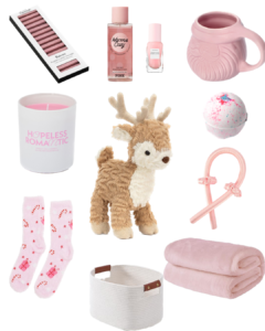 Christmas gift basket with pink gifts including mug, candle, blanket and socks.